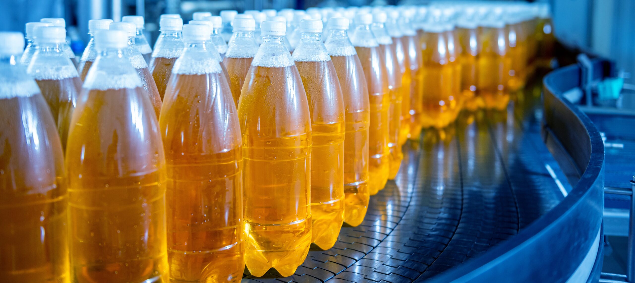 Conveyor belt with bottles for juice or water at a modern beverage plant
